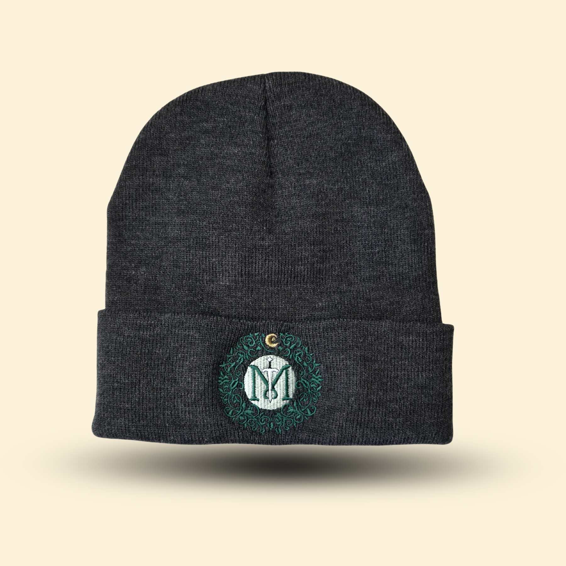 Mythic Manuscripts Logo Toque. Dark gray knit cap with green embroidered logo.