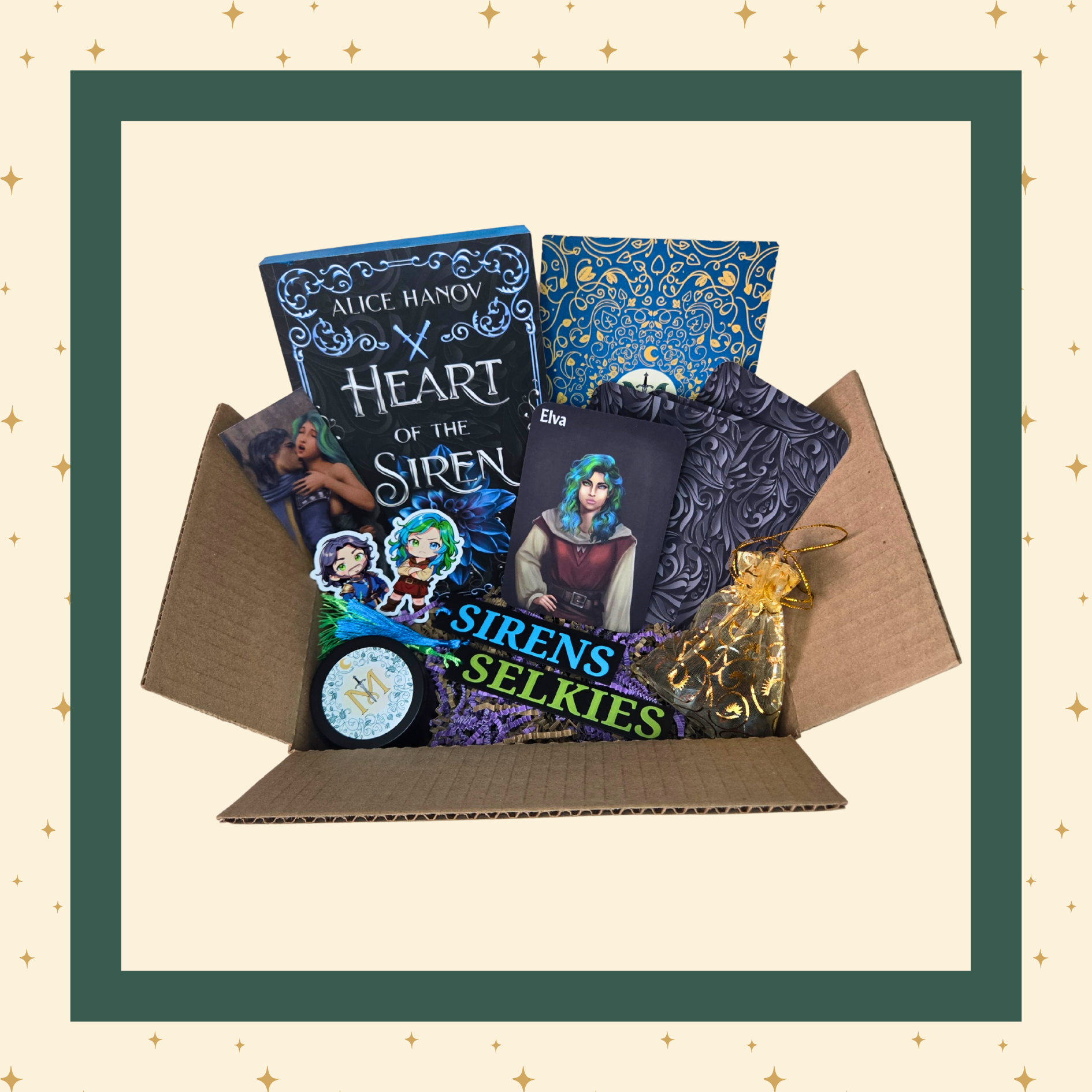 An open gift box containing a curated selection of items: a blue and black covered book titled "Heart of the Siren," art featuring the main characters of the book, a round candle container with a stylized "M" label, a set of resin polyhedral dice, several themed stickers, and additional small items.